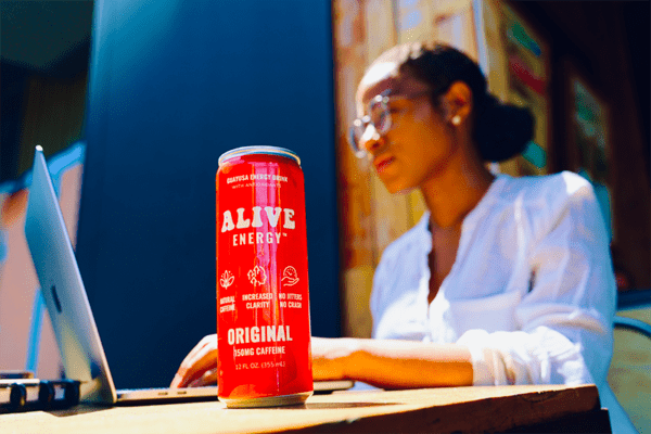 Woman working out with red Alive Energy can in foreground