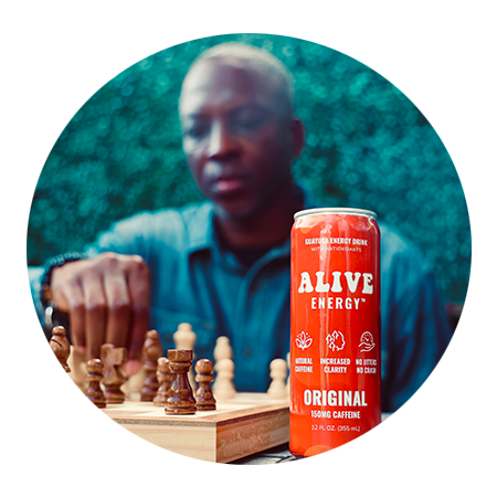 Man playing chess with red Alive Energy can in foreground