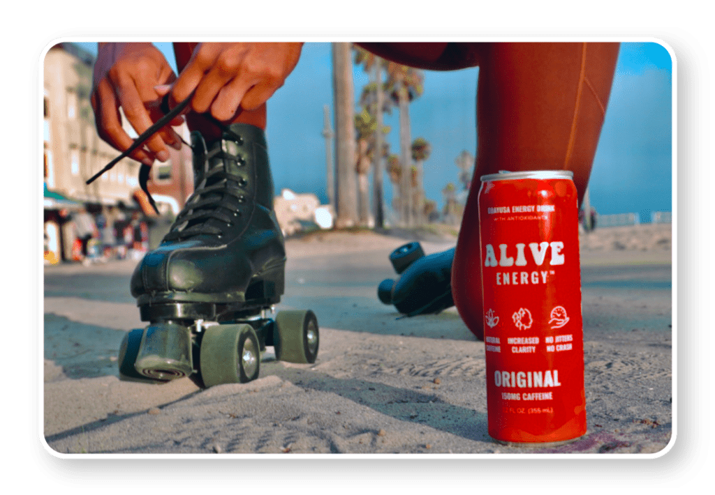 Woman lacing up rollerskates with red Alive Energy can in foreground